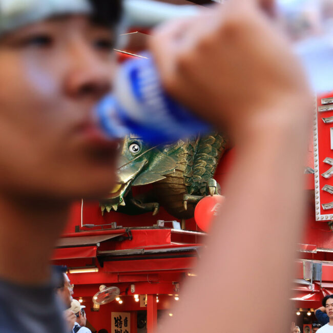 Picture about a person drinking water in Japan in a crowd